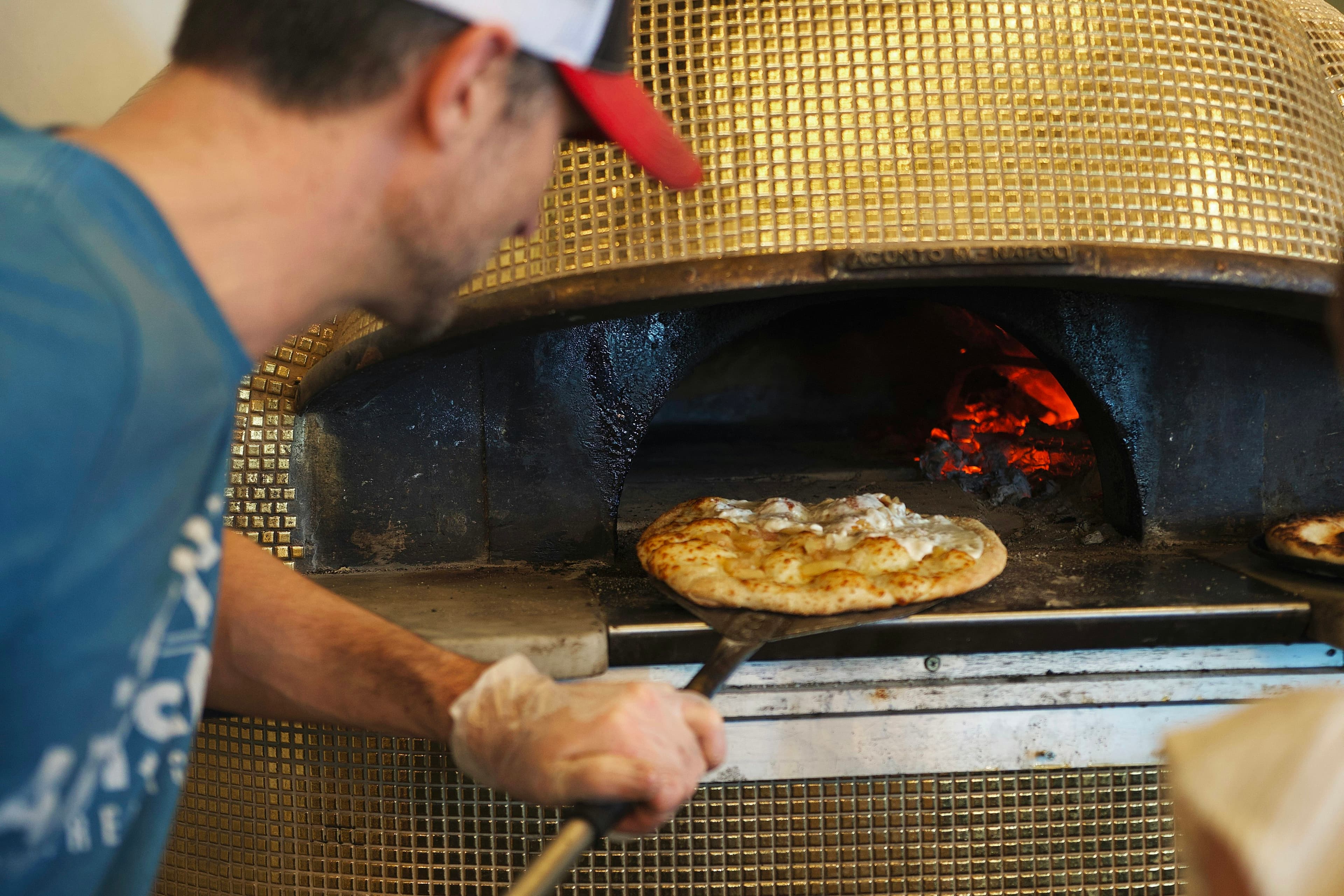 Pizzaiolo bei der Arbeit am Ofen